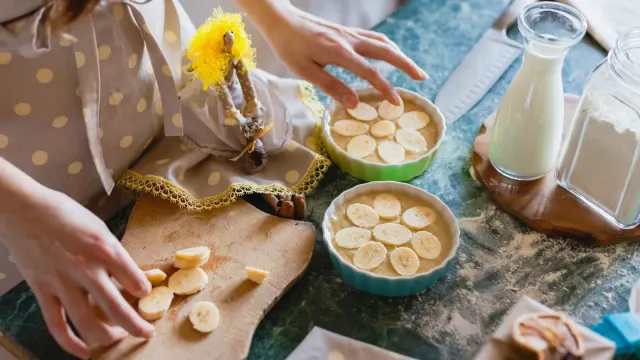 A dog sniffing banana slices set on a kitchen counter