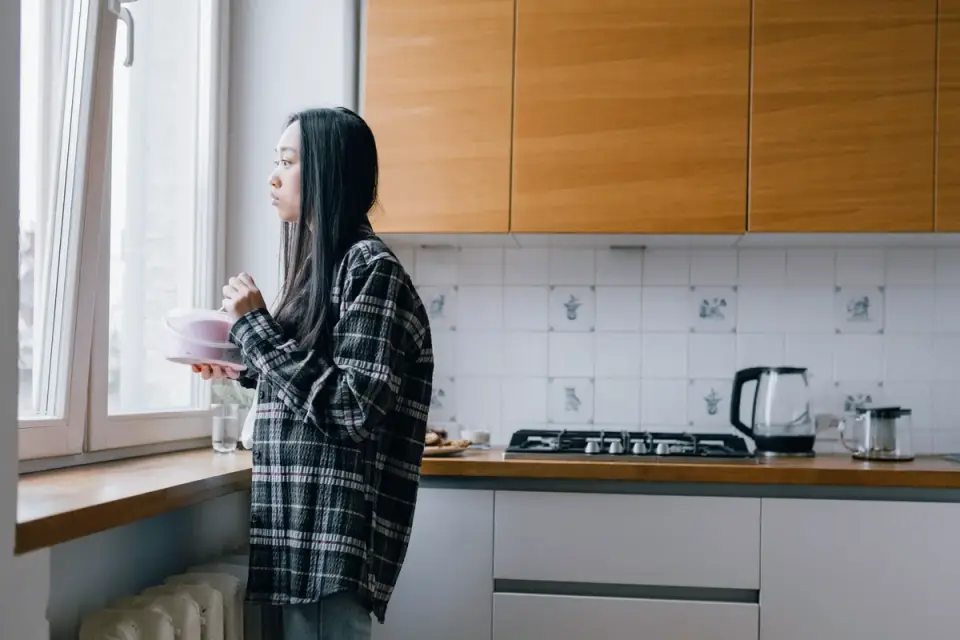 A senior dog eating from a bowl in a home kitchen