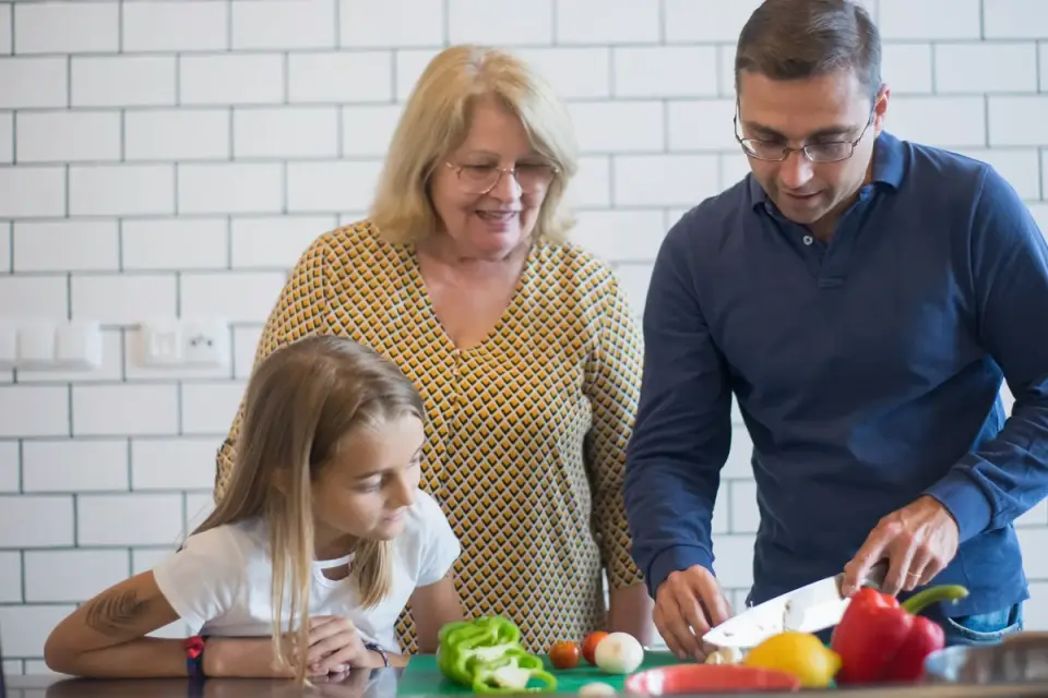 A veterinarian demonstrating proper vegetable prep to a dog owner in a clinic setting