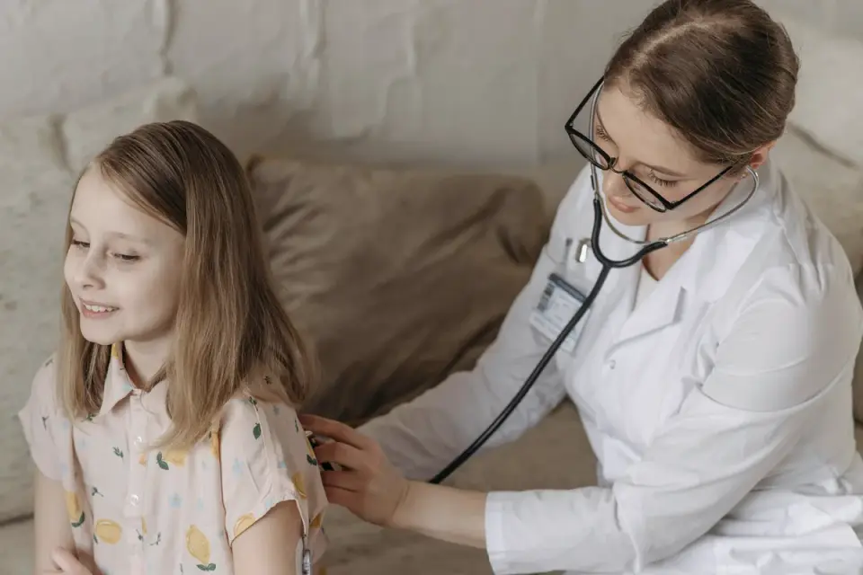 A veterinarian listening to a dog&#x27;s abdomen with a stethoscope