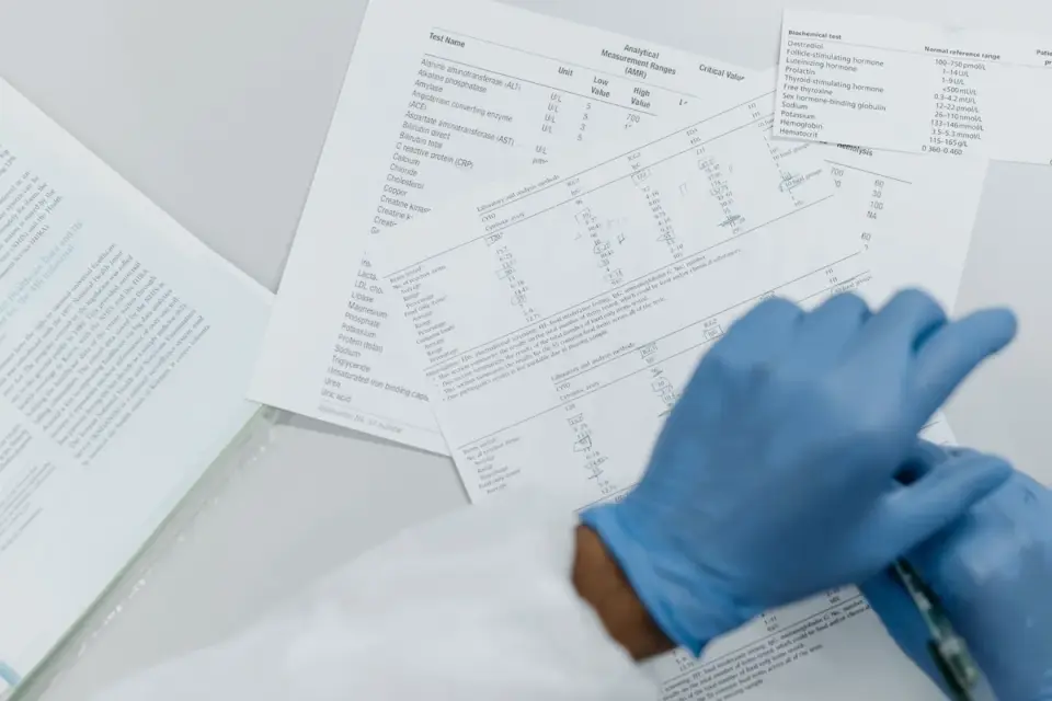 A veterinarian pointing to bloodwork results on a clipboard while a dog owner listens