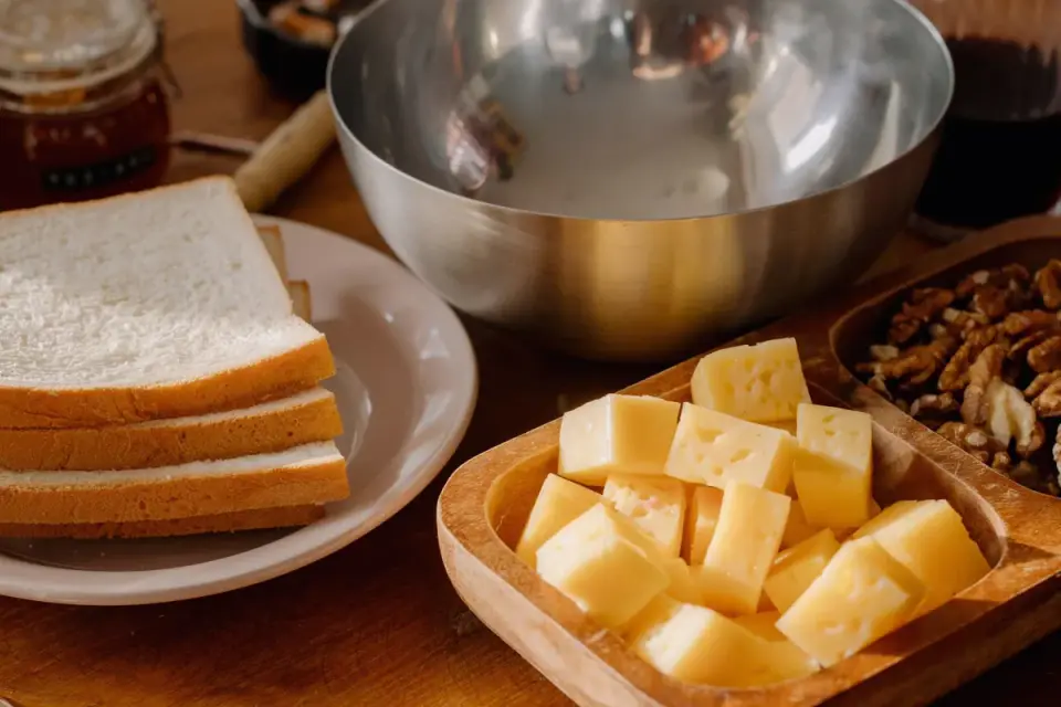 An assortment of cheese cubes on a kitchen counter with a dog waiting nearby