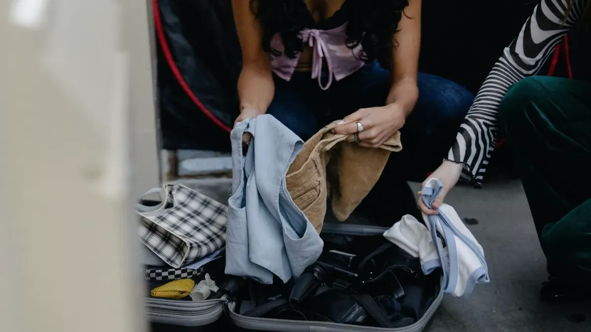 An owner packing an insulated travel bag with insulin and syringes next to a dog's travel crate