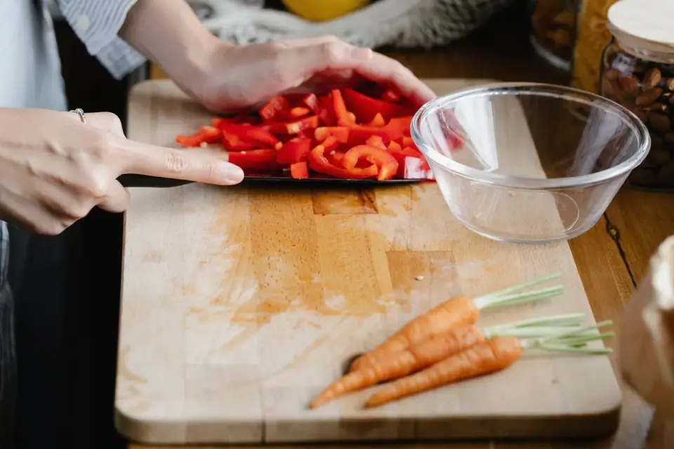 Carrots sliced into small bite-size pieces on a wooden cutting board