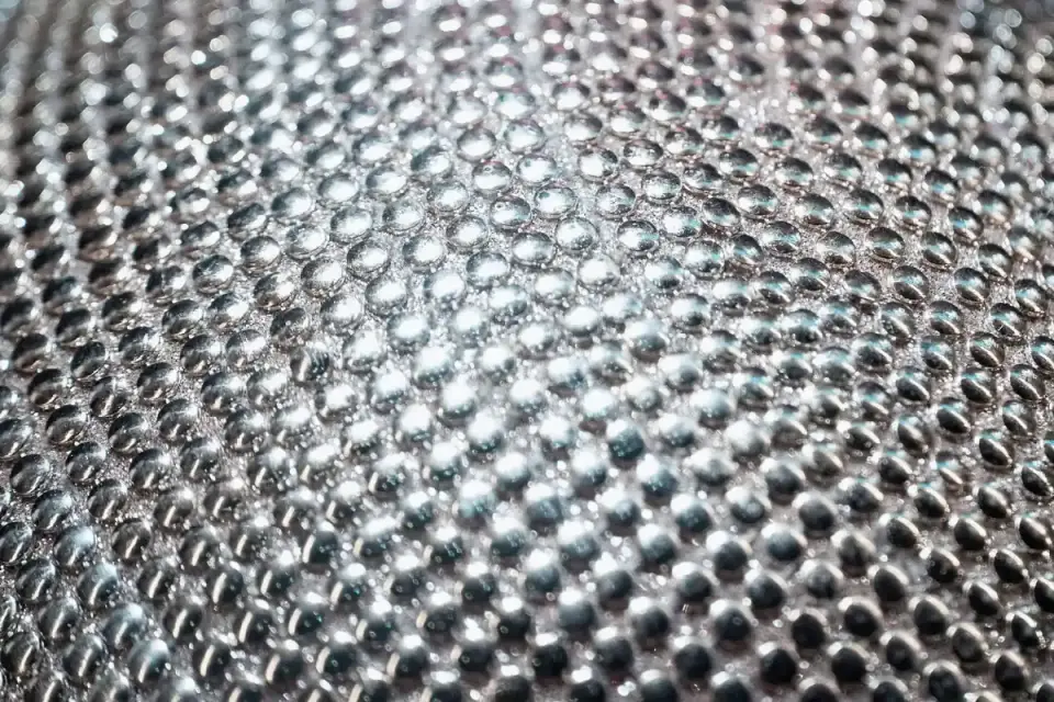 Close-up of reflective harness fabric catching light against a dark background