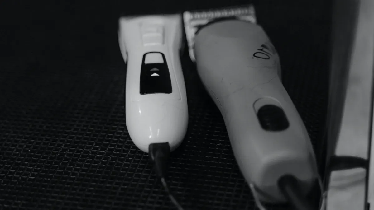 Dog nail clippers and a cordless nail grinder placed side by side on a grooming table