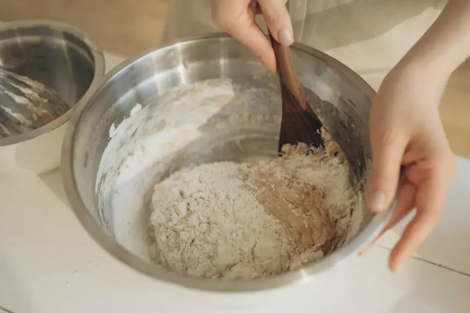 Owner pouring warm water into a bowl of freeze-dried dog food to rehydrate it