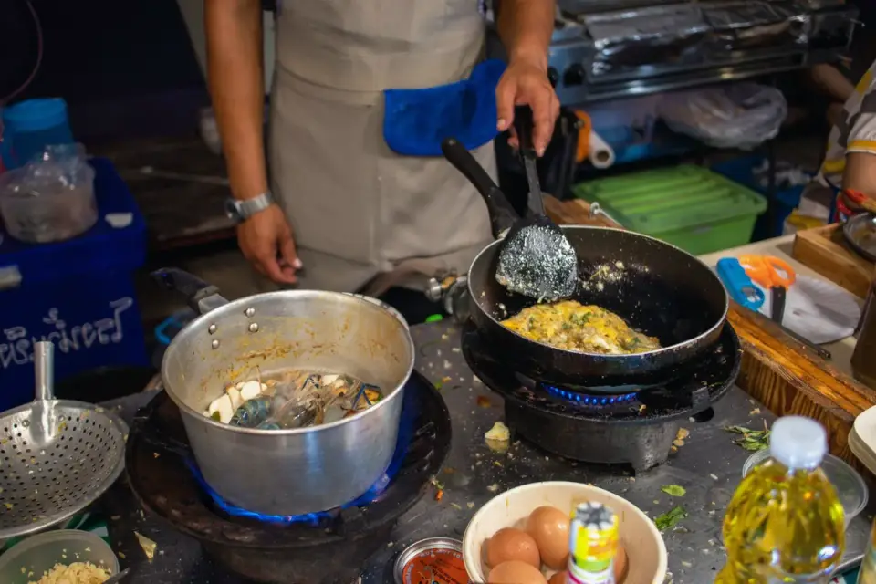 Plain scrambled eggs cooking in a stainless steel pan with no oil or seasoning