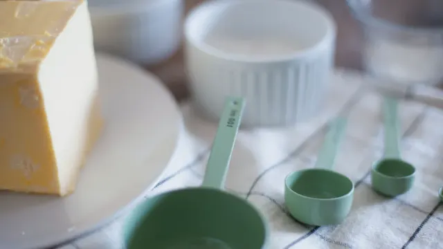 Three dog bowls made of stainless steel, ceramic, and plastic sitting side by side on a kitchen floor